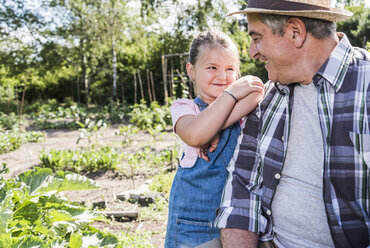 Smiling grandfather and granddaughter in the garden - UUF11318