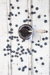 Glass of blueberry jam and blueberries on white wood - LVF06249