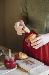 Nahaufnahme einer Frau, die hausgemachte Croissants mit Marmelade probiert - ALBF00145