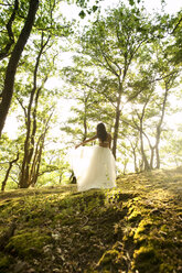 Rear view of young woman in forest wearing tulle skirt - MFRF00959