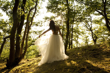 Rear view of young woman in forest wearing tulle skirt - MFRF00960