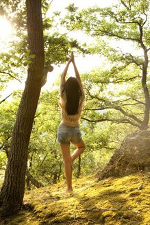 Junge Frau im Wald übt Yoga - MFRF00971