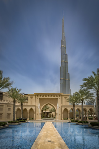 Vereinigte Arabische Emirate, Dubai, Burj Khalifa mit Häusern im traditionellen arabischen Stil und Wasserbecken, lizenzfreies Stockfoto