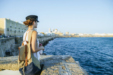 Spain, Andalusia, Cadiz, young woman looking at the sea - KIJF01676