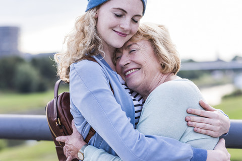 Glückliche Großmutter und Enkelin, die sich umarmen, lizenzfreies Stockfoto