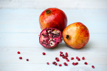 Whole and sliced omegranate and pomegranate seeds on wood - LBF01629