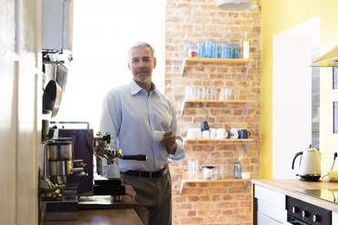 Geschäftsmann macht Kaffeepause in der Büroküche - FKF02449