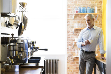 Geschäftsmann macht Kaffeepause in der Büroküche - FKF02450