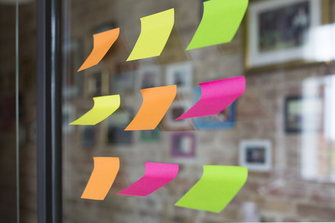 Adhesive notes on glass wall in office stock photo