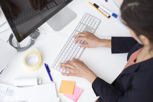 Frau benutzt Computertastatur am Schreibtisch im Büro - FKF02461