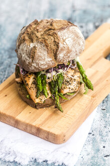 Lachsburger mit grünem Spargel und roter Kresse auf Schneidebrett - SARF03343