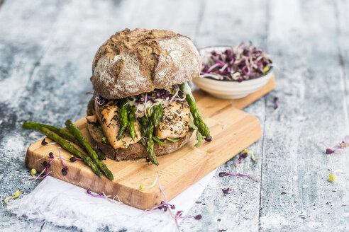 Lachsburger mit grünem Spargel und roter Kresse auf Schneidebrett - SARF03344