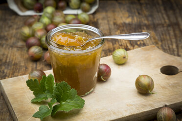 Glas mit Stachelbeermarmelade und Stachelbeeren auf einem Holzbrett - LVF06268