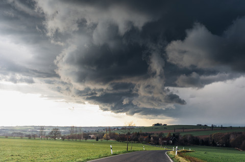 Stormy atmosphere over empty country road stock photo