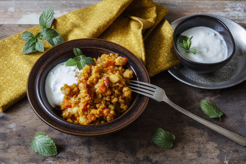 Gekochte rote Linsen mit Gemüse und Naturjoghurt mit Minze, lizenzfreies Stockfoto