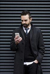 Businessman looking at cell phone - MAUF01188