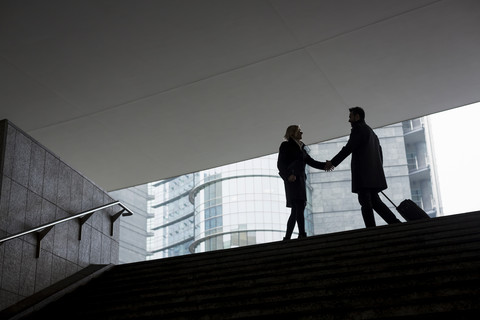 Geschäftsmann und Geschäftsfrau treffen sich in der Stadt, lizenzfreies Stockfoto