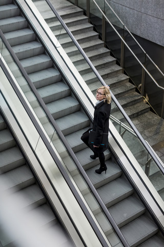 Geschäftsfrau auf Rolltreppe, lizenzfreies Stockfoto