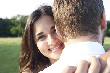 Porträt einer glücklichen jungen Frau, die ihren Partner umarmt - IGGF00045