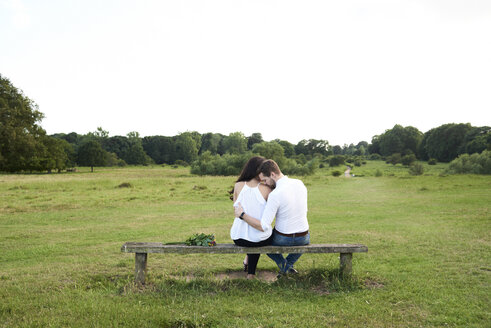 Rückansicht eines Paares auf einer Bank in einem Park - IGGF00046