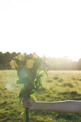 Hand einer Frau hält Blumenstrauß - IGGF00055