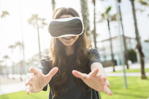 Junge Frau trägt VR-Brille im Freien - GIOF02980