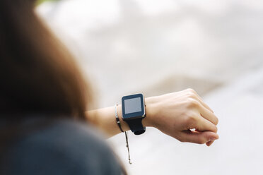 Woman checking her smartwatch - GIOF02981