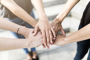 Close-up of three women stacking their hands - GIOF02994