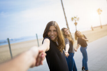 Happy young women holding hands outdoors - GIOF03000