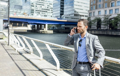 Businessman talking on the phone in the city - MGOF03470