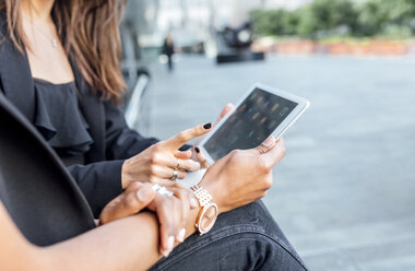 Close-up of two women using a tablet in the city - MGOF03480