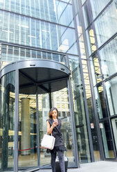 Businesswoman leaving an office building in the city - MGOF03509