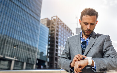 Businessman checking the time in the city - MGOF03521