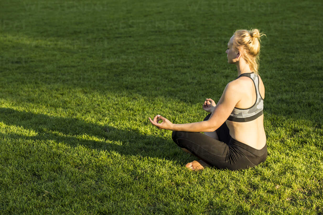 Woman doing yoga in park stock photo