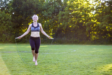 Woman skipping rope in park - JFEF00854