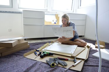 Woman reading assembly instructions at home - ECPF00010