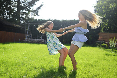 Zwei glückliche verspielte Mädchen im Garten - ECPF00033