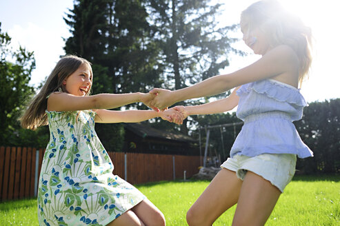 Zwei glückliche verspielte Mädchen im Garten - ECPF00034