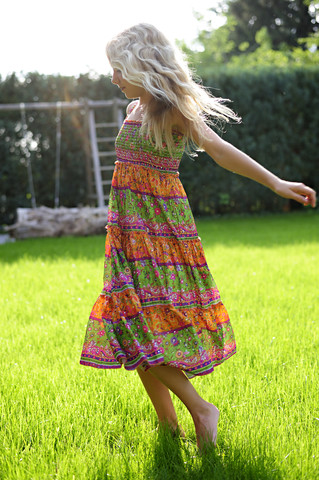 Girl wearing a dress playing in garden stock photo