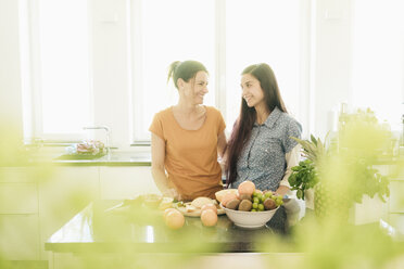 Zwei lächelnde Frauen in der Küche bereiten Obst zu - JOSF01254