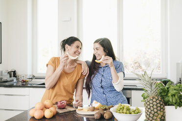 Two happy women in kitchen preparing fruit - JOSF01274