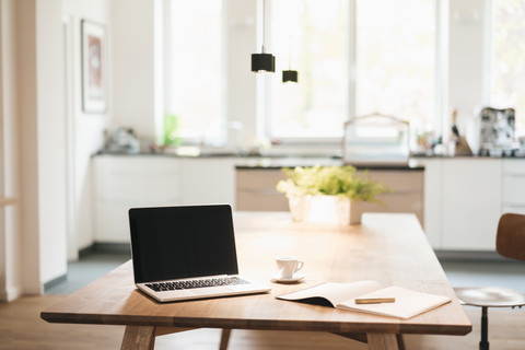 Laptop und Notizbuch auf dem Tisch zu Hause, lizenzfreies Stockfoto