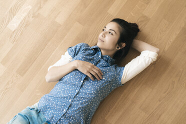 Woman lying on wooden floor - JOSF01296