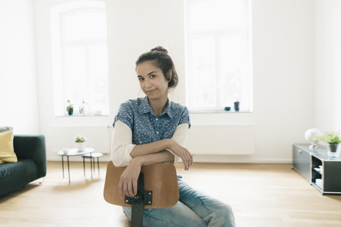 Porträt einer Frau, die zu Hause auf einem Stuhl sitzt, lizenzfreies Stockfoto