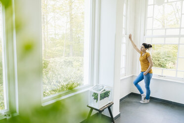 Woman with herbs in glass box at the window - JOSF01301