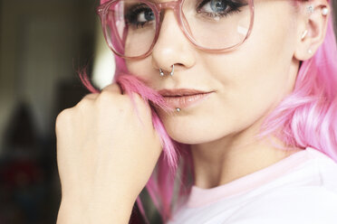 Porträt einer jungen Frau mit rosa Haaren, Brille und Piercings - IGGF00067