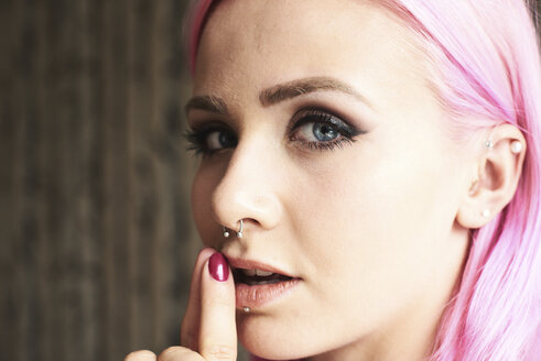 Portrait of young woman with pink hair and piercings - IGGF00068