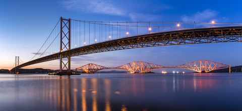 Großbritannien, Schottland, Fife, Edinburgh, Mündung des Firth of Forth, Forth Bridge und Forth Road Bridge bei Sonnenuntergang, lizenzfreies Stockfoto