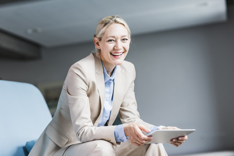 Porträt einer glücklichen Geschäftsfrau mit Tablet, lizenzfreies Stockfoto