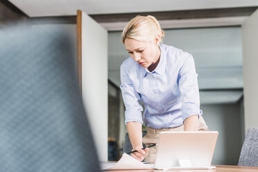 Geschäftsfrau arbeitet am Schreibtisch im Büro - UUF11411